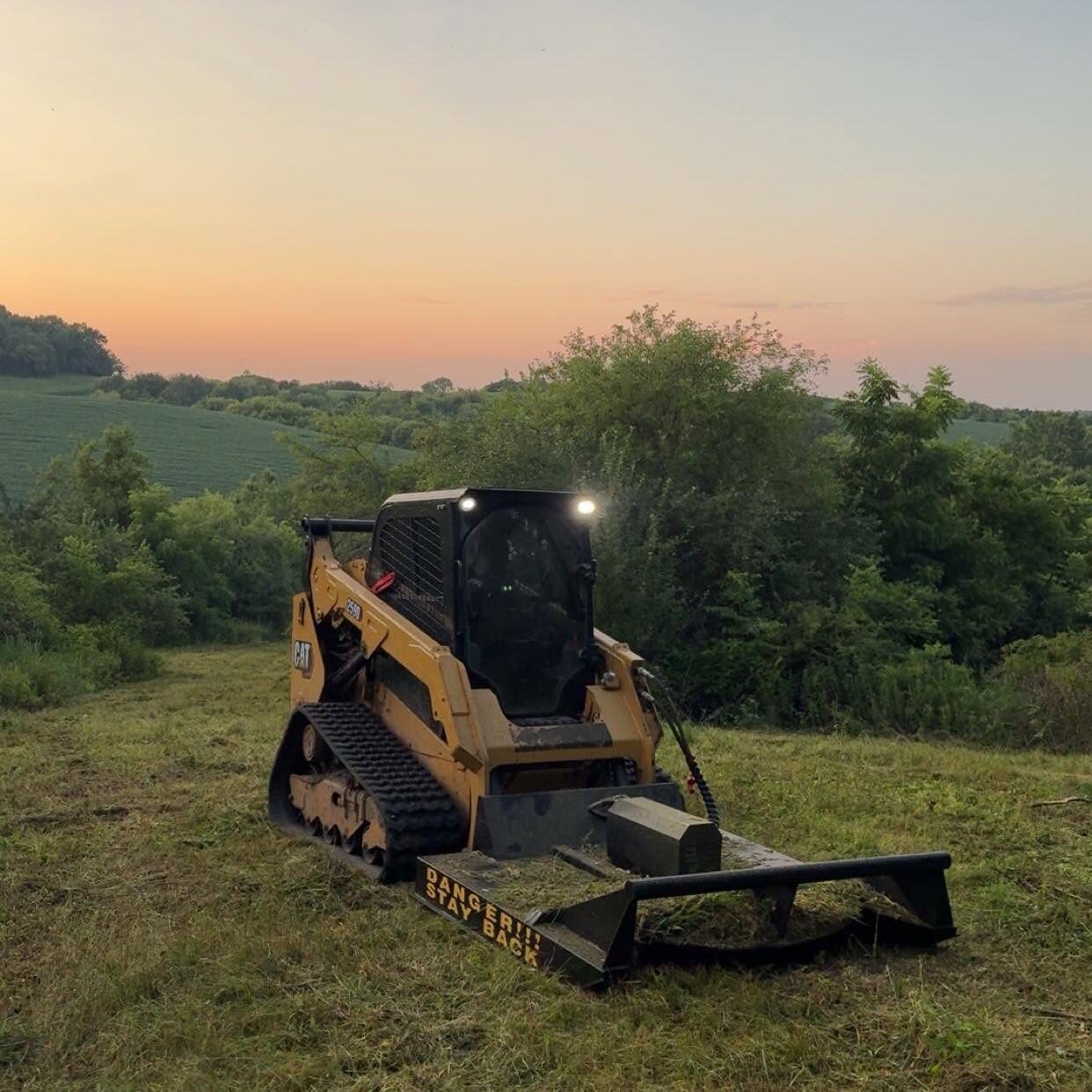 CAT compact track loader mulching a hillside at sunset near Arcadia, Wisconsin